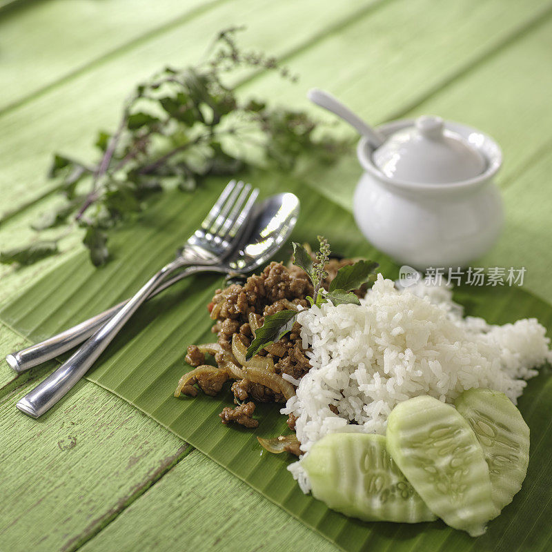 泰式菜肴:香蕉叶上的炸猪肉配圣罗勒(pak krapao moo)，配米饭。